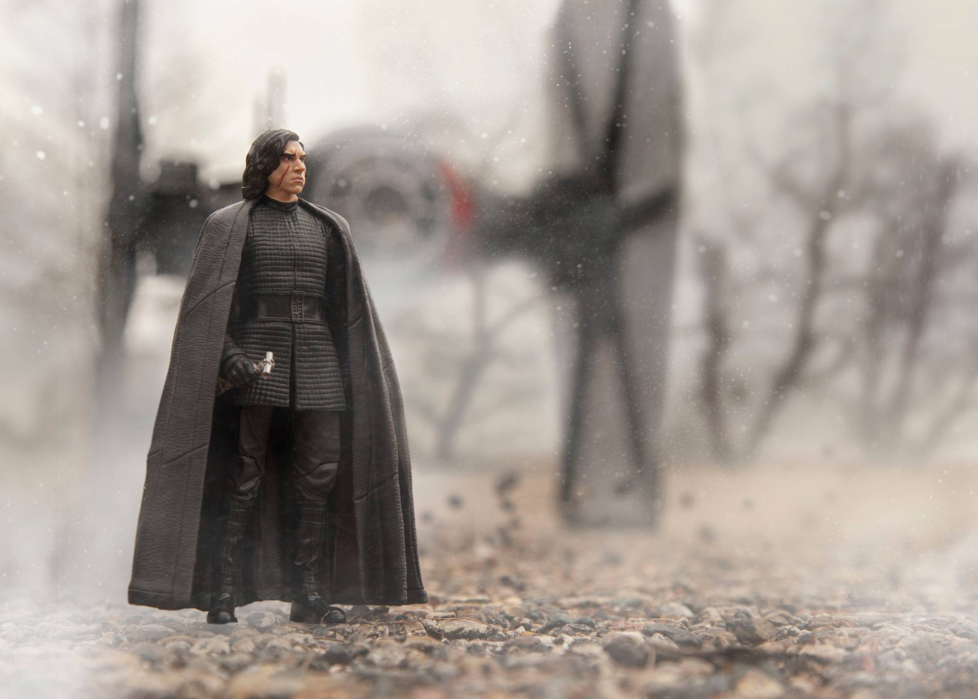 kylo ren figurine staning in front of tie fighter with snow effects over scene